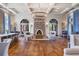 Spacious lounge with wood floors, stone fireplace, coffered ceilings and a large chandelier at 28683 Lucero Ln, Wesley Chapel, FL 33543