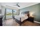 The main bedroom has wood-look tile flooring, a tray ceiling and a great view of the lake at 28683 Lucero Ln, Wesley Chapel, FL 33543