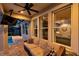 Covered patio area with comfortable seating, fan, and views through large windows into the home's interior at 28683 Lucero Ln, Wesley Chapel, FL 33543