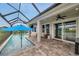 Entertain and relax in this covered outdoor space with a swimming pool, ceiling fans, and lake views at 28683 Lucero Ln, Wesley Chapel, FL 33543