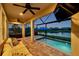 Relax on the covered patio overlooking the pool and lake for a delightful evening in this outdoor space at 28683 Lucero Ln, Wesley Chapel, FL 33543