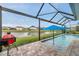 Screened-in pool with BBQ, outdoor space, and waterfront views offers relaxation and entertainment at 28683 Lucero Ln, Wesley Chapel, FL 33543