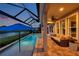 Enjoy the evening on this covered patio with a pool and lake view for a relaxing experience at 28683 Lucero Ln, Wesley Chapel, FL 33543