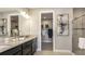 Bathroom with double vanity, walk-in closet, and glass enclosed shower at 29536 Zupetta Ln, Wesley Chapel, FL 33545