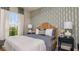 Bright bedroom with a patterned wallpaper, large window with natural light, and a comfortable bed at 29536 Zupetta Ln, Wesley Chapel, FL 33545