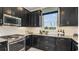 This kitchen features dark cabinets, stainless steel appliances, and a window with a view at 29536 Zupetta Ln, Wesley Chapel, FL 33545