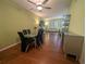 Dining room with hardwood floors, ceiling fan, and view into the adjacent living room at 2983 Covewood Pl, Clearwater, FL 33761
