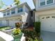 Townhome exterior featuring a two-car garage with landscaping and well-maintained bushes at 2983 Covewood Pl, Clearwater, FL 33761