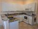 Well-maintained kitchen featuring white cabinets, granite countertops, and modern appliances at 2983 Covewood Pl, Clearwater, FL 33761