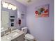 Stylish powder room with granite countertop, decorative mirror, and lavender painted walls at 2983 Covewood Pl, Clearwater, FL 33761