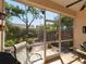 Screened porch with a ceiling fan overlooking a well-maintained backyard garden at 2983 Covewood Pl, Clearwater, FL 33761