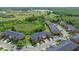 Wide aerial of townhome community featuring trees, landscaping, roads, and parking areas at 30130 Mossbank Dr, Wesley Chapel, FL 33543