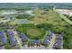 Aerial view of townhomes showing the roofs, parking, and surrounding greenery and ponds at 30130 Mossbank Dr, Wesley Chapel, FL 33543