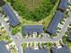 Aerial view of townhomes showing the roofs, parking, landscaping, and roads at 30130 Mossbank Dr, Wesley Chapel, FL 33543