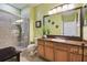Full bathroom with walk in shower, vanity, toilet and green walls at 30130 Mossbank Dr, Wesley Chapel, FL 33543
