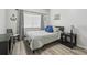 Cozy bedroom with neutral walls, light wood flooring, and beach-themed decor at 30130 Mossbank Dr, Wesley Chapel, FL 33543