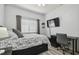 Well-lit bedroom with modern decor, desk, and wall-mounted TV at 30130 Mossbank Dr, Wesley Chapel, FL 33543