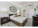 Bedroom with wood-look flooring, queen bed and two side tables with lamps at 30130 Mossbank Dr, Wesley Chapel, FL 33543