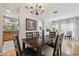 Spacious dining room with hardwood floors, wooden table, and views into the living room and kitchen at 30130 Mossbank Dr, Wesley Chapel, FL 33543