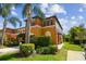 Beautifully landscaped townhome with a lush green lawn, mature landscaping and private garage at 30130 Mossbank Dr, Wesley Chapel, FL 33543