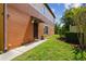 Townhome exterior with a lush green lawn and mature landscaping on a sunny day at 30130 Mossbank Dr, Wesley Chapel, FL 33543