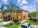 Two-story townhome featuring vibrant colors, a well-maintained lawn, and lush landscaping at 30130 Mossbank Dr, Wesley Chapel, FL 33543