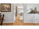 Hardwood hallway connecting rooms, with views into the kitchen and living area, offering an open layout at 30130 Mossbank Dr, Wesley Chapel, FL 33543