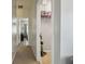 Hallway view into bedroom and laundry room with stacked towels and vacuum at 30130 Mossbank Dr, Wesley Chapel, FL 33543