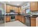 Kitchen with stainless steel appliances, wooden cabinets, tile backsplash, and a wine cooler at 30130 Mossbank Dr, Wesley Chapel, FL 33543
