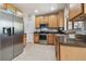 Kitchen with stainless steel appliances, wooden cabinets, tile backsplash, and a stainless steel refrigerator at 30130 Mossbank Dr, Wesley Chapel, FL 33543