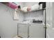 Laundry room features a white washer and dryer with shelving for storage at 30130 Mossbank Dr, Wesley Chapel, FL 33543