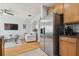 Open concept living room with hardwood floors leading into the kitchen with stainless steel appliances and refrigerator at 30130 Mossbank Dr, Wesley Chapel, FL 33543
