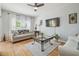 Bright living room with hardwood floors, a ceiling fan and large windows letting in natural light at 30130 Mossbank Dr, Wesley Chapel, FL 33543