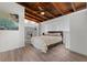 Bedroom with wood-beam ceiling, fireplace, and light wood flooring at 3214 E Maritana Dr, St Pete Beach, FL 33706