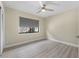 Cozy bedroom with modern ceiling fan, warm-toned walls, and a window with a view to the outside at 3214 E Maritana Dr, St Pete Beach, FL 33706