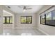 Serene bedroom features tile floors, a ceiling fan, and large windows offering natural light and peaceful views at 3214 E Maritana Dr, St Pete Beach, FL 33706