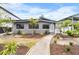 Charming gray home with landscaped front yard and walkway to the front door at 3214 E Maritana Dr, St Pete Beach, FL 33706