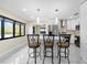 Modern kitchen featuring white cabinetry, stainless steel appliances, and barstool seating at 3214 E Maritana Dr, St Pete Beach, FL 33706