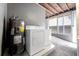 Laundry room features washer, dryer, hot water tank, and tiled floor at 3214 E Maritana Dr, St Pete Beach, FL 33706