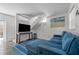 Living room featuring blue couch, accent rug, flat screen tv and stairs at 3214 E Maritana Dr, St Pete Beach, FL 33706