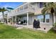 Outdoor patio with seating and a grill, overlooking green space and waterfront views at 400 Larboard Way # 103, Clearwater, FL 33767