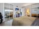 Bedroom featuring neutral tones, simple decor, and mirrored closet doors reflecting mounted TV at 400 Larboard Way # 103, Clearwater, FL 33767