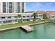 Scenic waterfront view featuring a private dock surrounded by lush greenery and condo buildings at 400 Larboard Way # 103, Clearwater, FL 33767