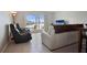 Living room with waterfront view, sliding glass doors to patio, comfortable seating, and tile floors at 400 Larboard Way # 103, Clearwater, FL 33767