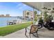 Enjoy stunning waterfront views from this covered patio with a dock and lush green lawn at 400 Larboard Way # 103, Clearwater, FL 33767