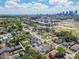 Expansive aerial view showcasing a residential area, with lush greenery and buildings, and a cityscape in the distance at 413 W Park Ave # 1, Tampa, FL 33602