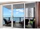 Inviting balcony with comfortable seating and stunning ocean views through sliding glass doors at 450 S Gulfview Blvd # 802, Clearwater Beach, FL 33767
