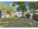 Spacious back yard with a white vinyl fence, mature trees, and a storage shed at 4606 Copper Ln, Plant City, FL 33566