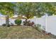 Landscaped backyard features a vibrant garden bed along a white fence, enhancing the property's charm at 4606 Copper Ln, Plant City, FL 33566