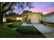 Charming home at twilight with a well-manicured lawn and mature tree providing shade at 4606 Copper Ln, Plant City, FL 33566